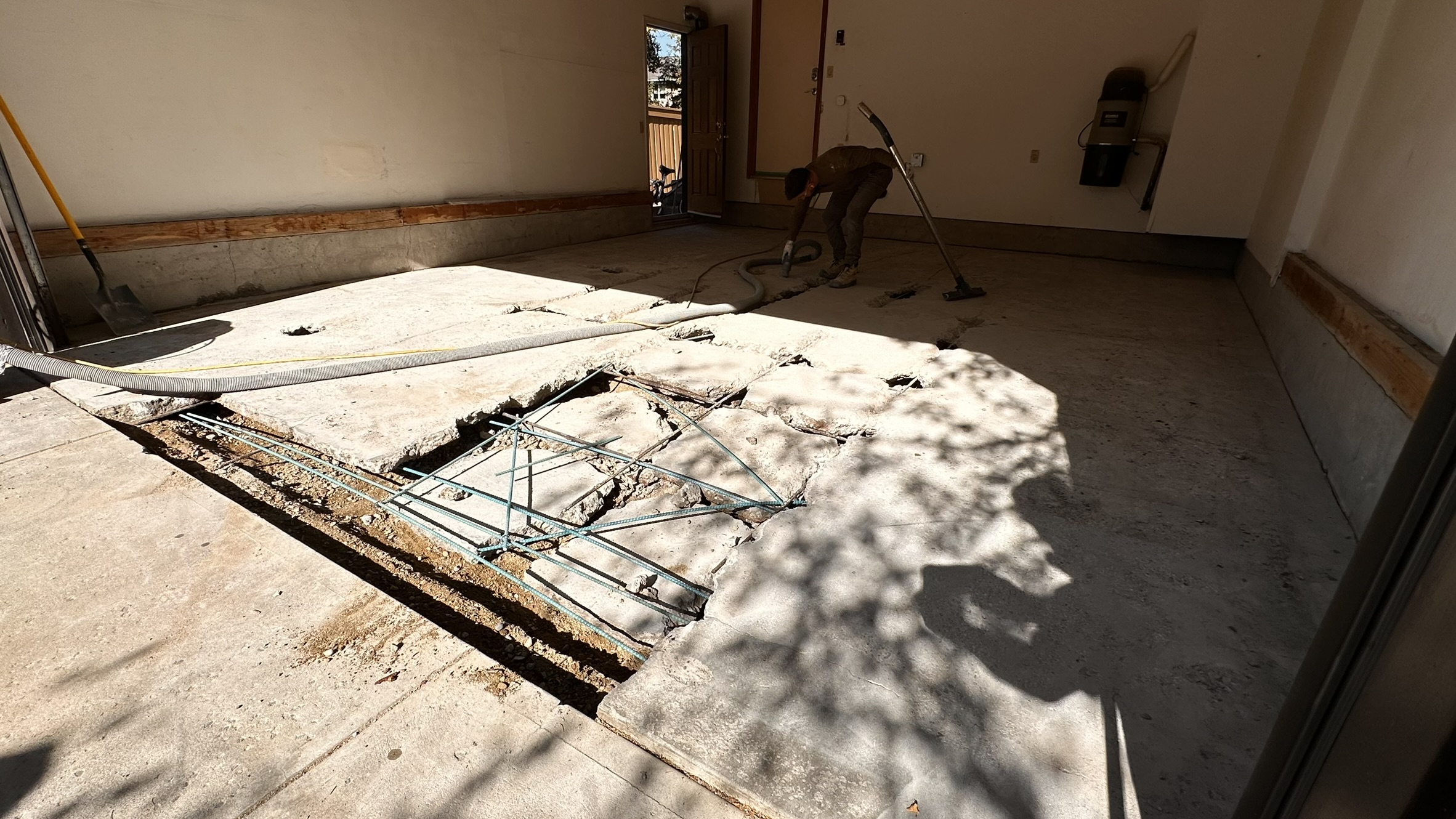 Concrete Repair Services Jacksonville, FL | Con Cure USA IMG 8152 Cracked concrete floor with exposed rebar, showing disrepair and structural issues in sunlight.