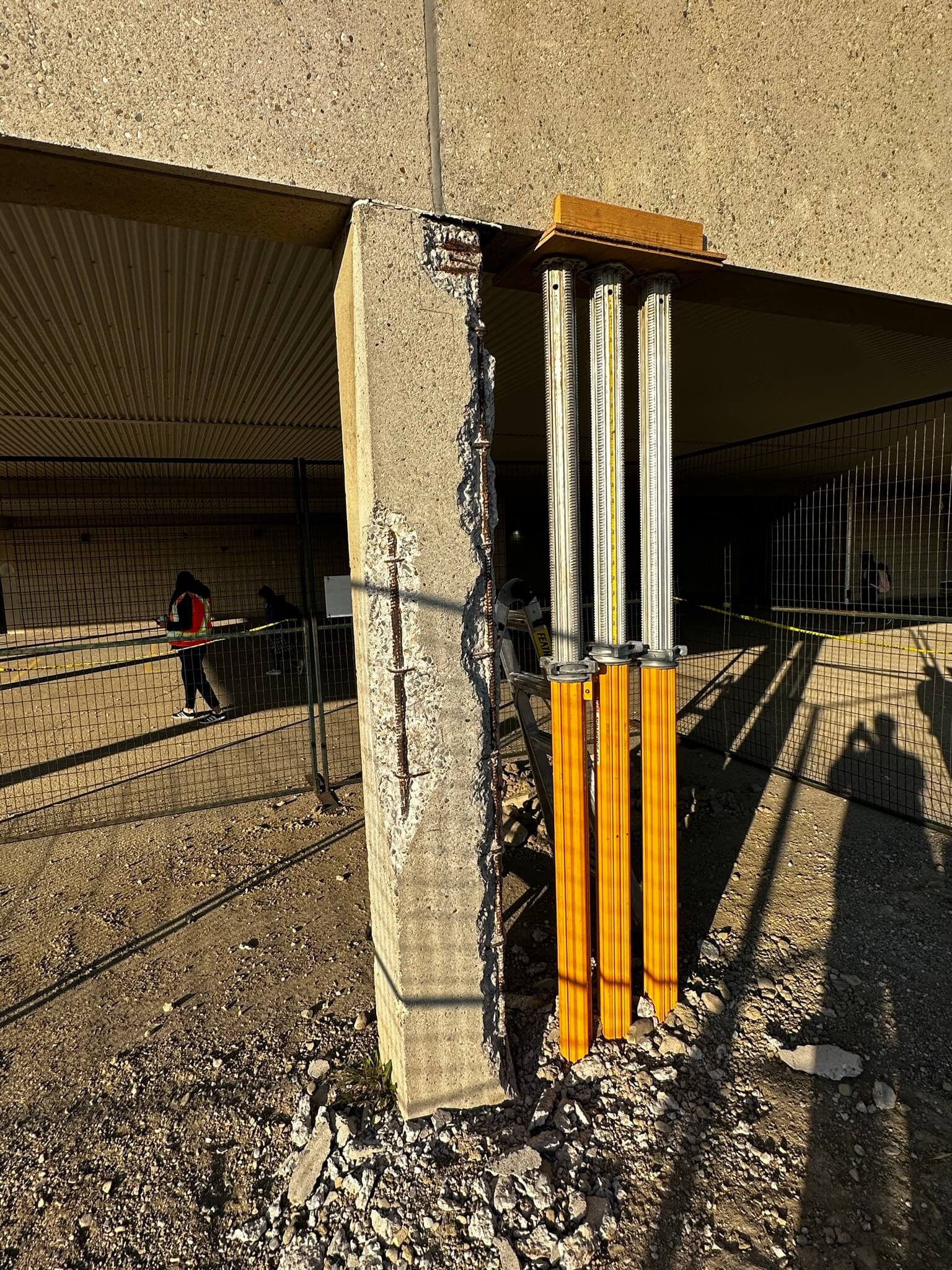 A man stands beside a damaged building, highlighting the need for Con Cure Restoration services.